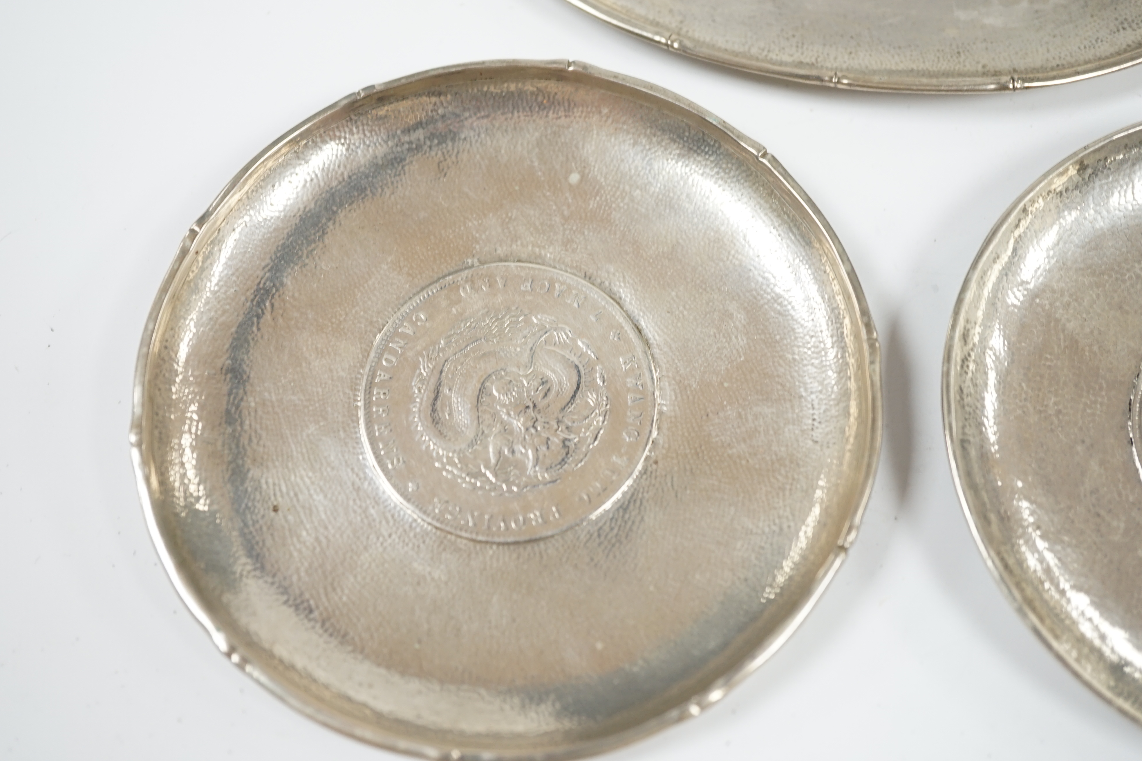 Three assorted small Chinese white metal dish, each inset with a coin, largest 11.8cm. Condition - fair